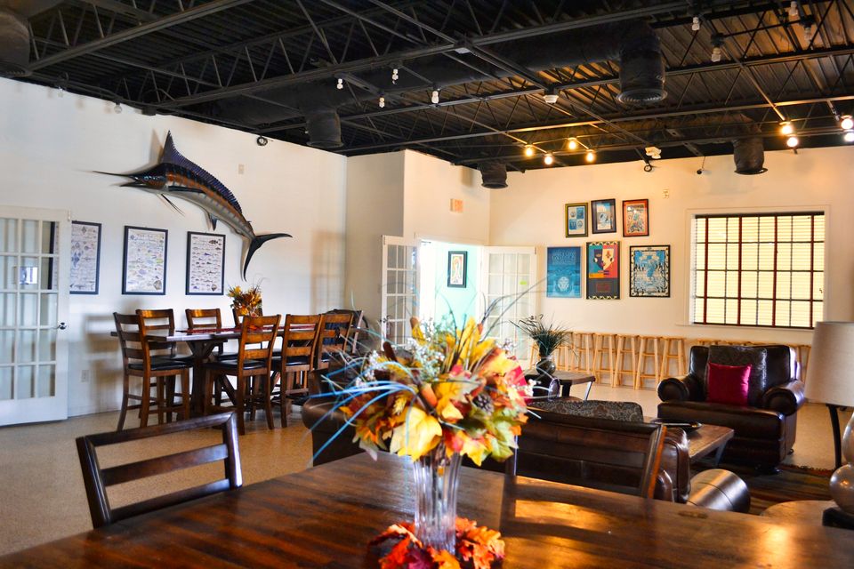The clubhouse social room with dining tables, a marlin on the wall and a lounge area