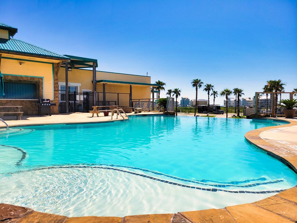 The infinity pool at Sandpiper RV Resort with the clubhouse and palms behind it